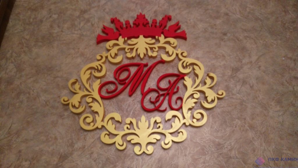 На фото изображена монограмма с инициалами МА , выполнена из пенопласта, окрашена красным цветом и  под золото